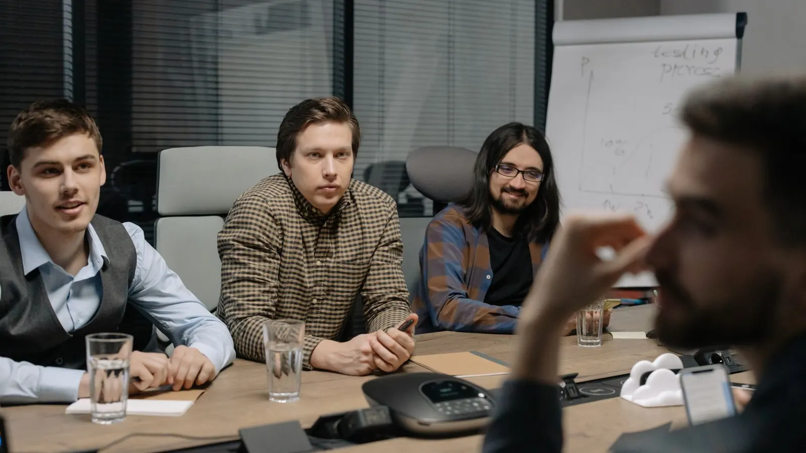 A group discussing documents and open laptops across a meeting table.